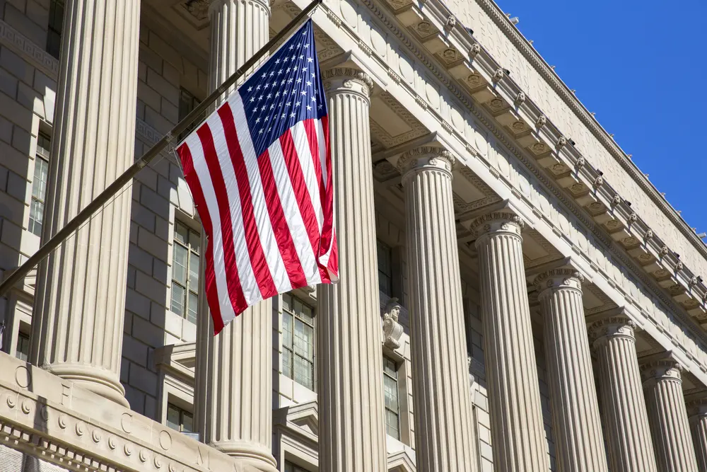 The image shows the American flag flying at the Department of Commerce in Washington DC, America. This scene represents the context of 508 Compliance Services, highlighting the importance of ensuring accessibility and compliance with Section 508 standards for federal agencies and institutions.