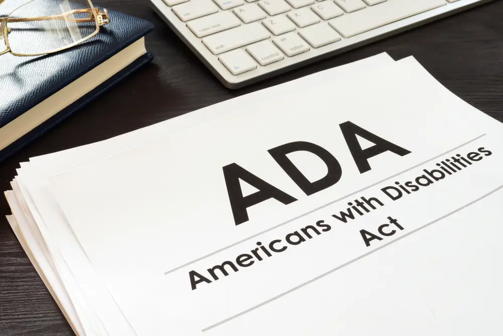 An image featuring the Americans with Disabilities Act (ADA) logo alongside a pair of glasses, symbolizing the importance of accessibility and empowerment for individuals with visual impairments.