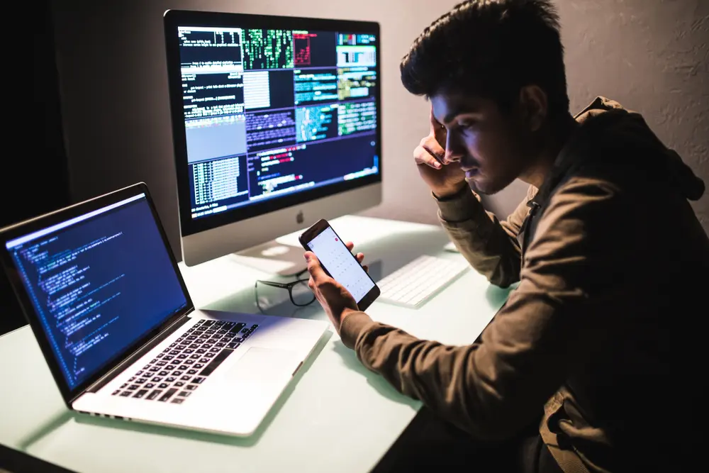 Indian male programmers are shown testing application security developed on a smartphone. This image represents the context of iOS App Testing Services, highlighting their efforts to ensure the security and integrity of iOS applications.