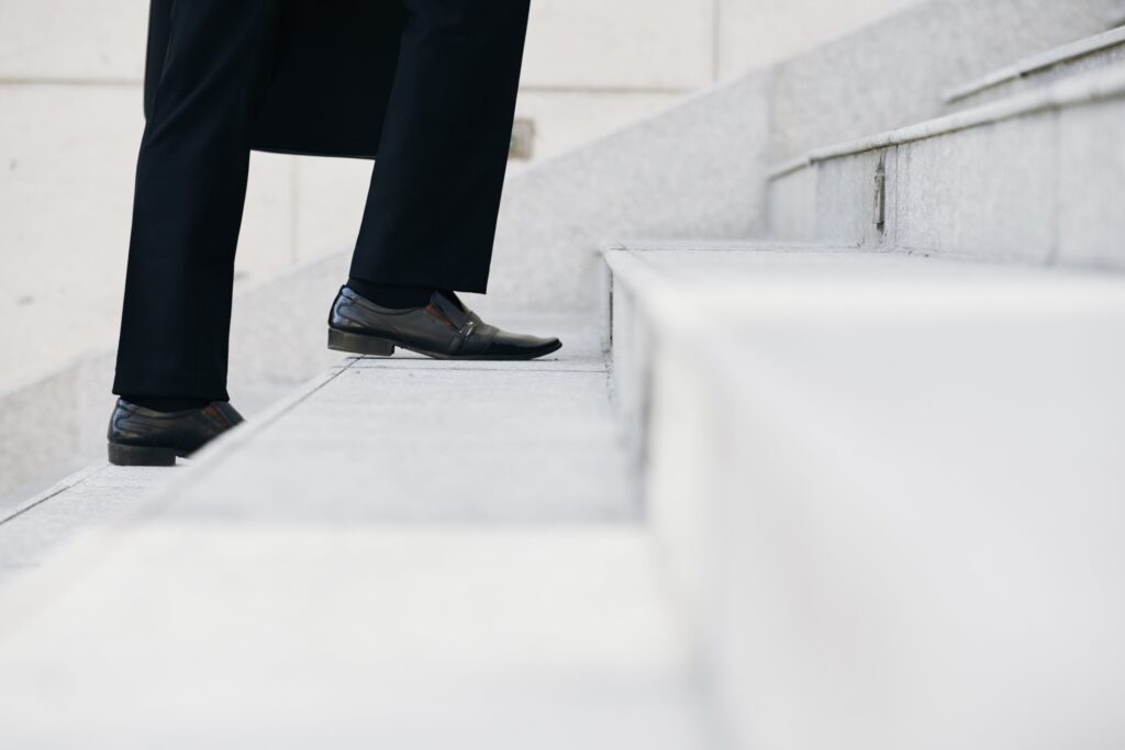 person in black suit walking up steps