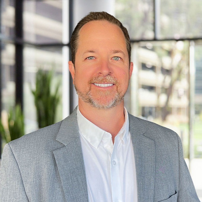 Headshot of Brian Allain in gray suit and white shirt