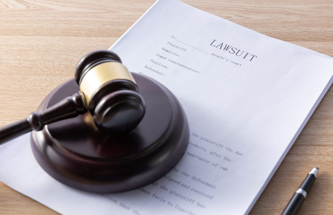 high-angle-shot-gavel-lawsuit-papers-wooden-surface-min gavel and lawsuit paperwork