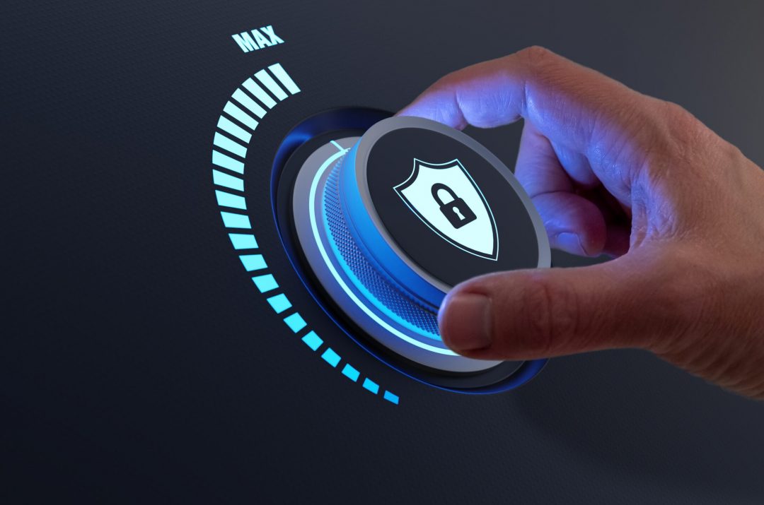 Security,Concept,With,Person,Increasing,The,Protection,Level,By,Turning cybersecurity knob with a person's hand turning it all the way up to max security