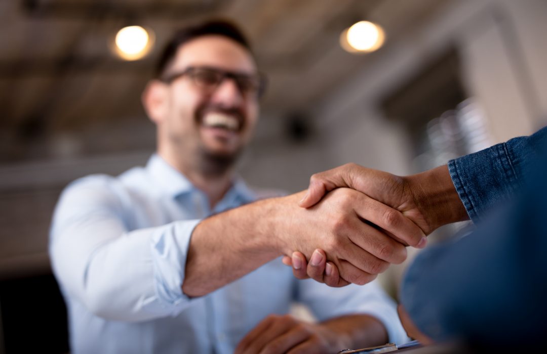 business man smiling while shaking hands